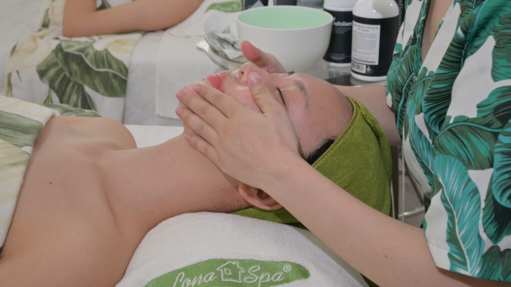 Thao tác massage mặt bằng tay cho khách đang nằm trên giường trị liệu — Phòng khám Chuyên khoa Da liễu Lona Skin Lab, Cần Thơ