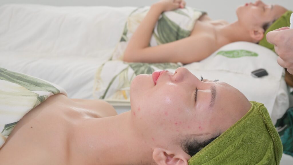 Khách nằm nghỉ trong lúc dưỡng chất thẩm thấu, khăn quấn gọn quanh đầu — Phòng khám Chuyên khoa Da liễu Lona Skin Lab, Cần Thơ