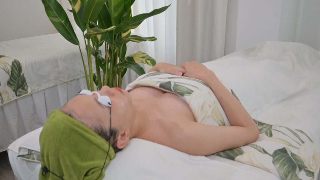Khách nằm nghỉ trên giường trị liệu, cạnh cửa sổ có cây xanh — Phòng khám Chuyên khoa Da liễu Lona Skin Lab, Cần Thơ