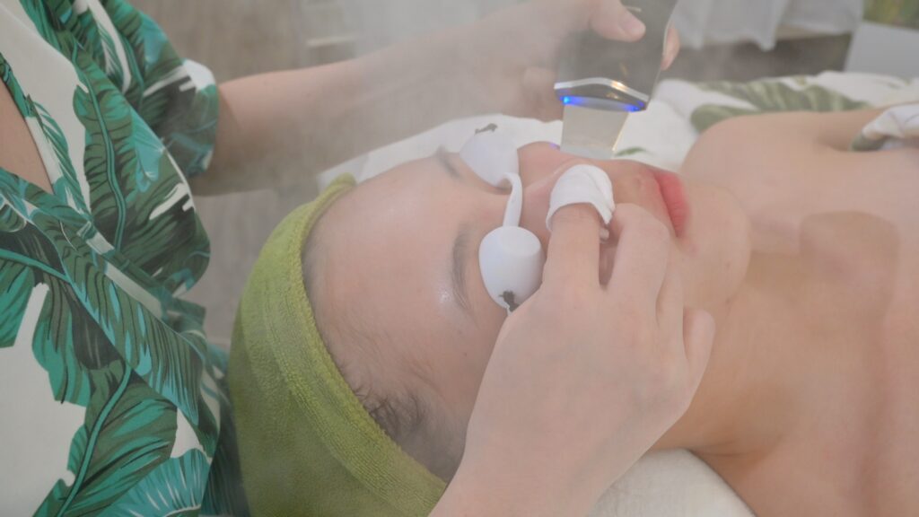 Thiết bị hai đầu tròn được áp lên vùng trán và má khách — Phòng khám Chuyên khoa Da liễu Lona Skin Lab, Cần Thơ