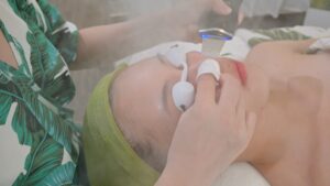 Thiết bị hai đầu tròn được áp lên vùng trán và má khách — Phòng khám Chuyên khoa Da liễu Lona Skin Lab, Cần Thơ